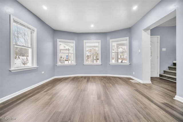 spare room featuring recessed lighting, stairway, baseboards, and wood finished floors