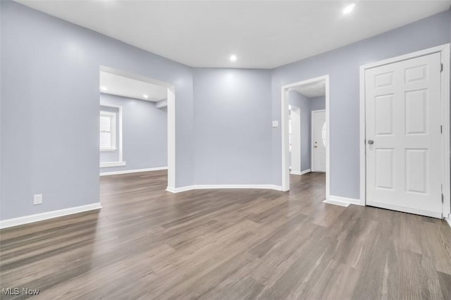 unfurnished room with recessed lighting, wood finished floors, and baseboards