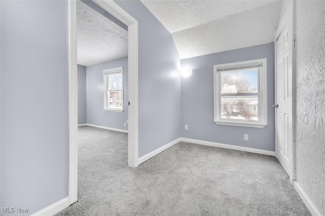 unfurnished room with carpet, a textured ceiling, and baseboards