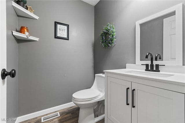 bathroom with vanity, hardwood / wood-style flooring, and toilet