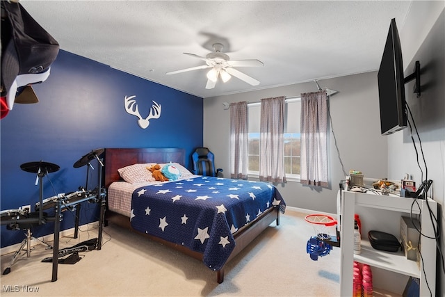 carpeted bedroom with ceiling fan and a textured ceiling