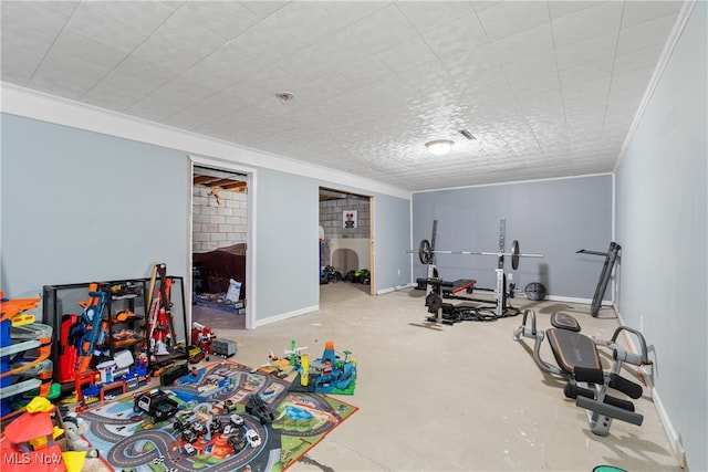 workout area featuring concrete flooring and crown molding