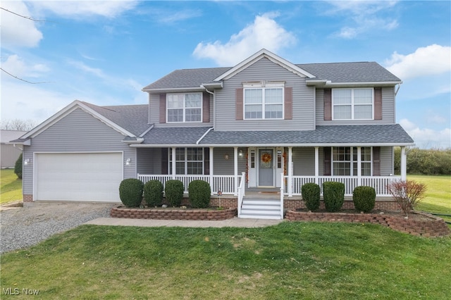 view of front of house with covered porch, a front yard, and a garage