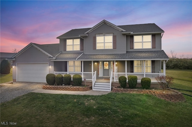 view of front facade with a lawn, a garage, and covered porch