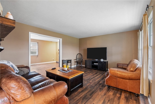 living room with dark hardwood / wood-style flooring and a textured ceiling