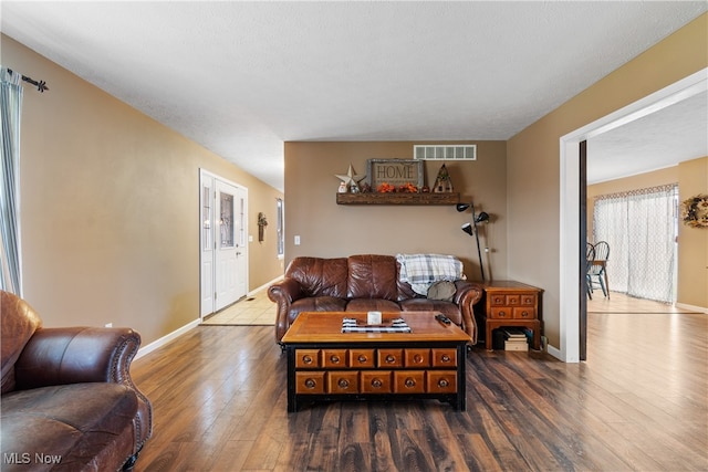 living room with dark hardwood / wood-style floors and a textured ceiling