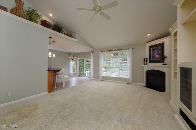 unfurnished living room featuring light carpet, ceiling fan with notable chandelier, and high vaulted ceiling