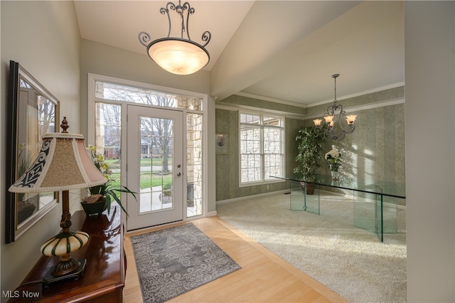 entrance foyer featuring a chandelier, wood-type flooring, and lofted ceiling