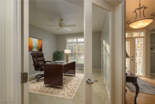 office space featuring french doors, light colored carpet, and ceiling fan