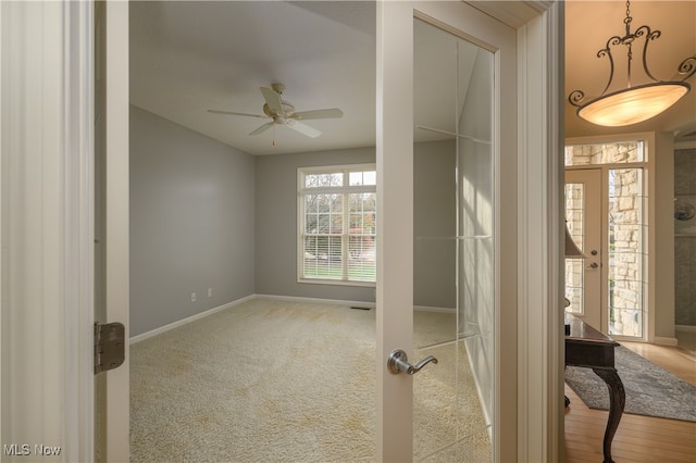 unfurnished room with french doors, light hardwood / wood-style flooring, and ceiling fan