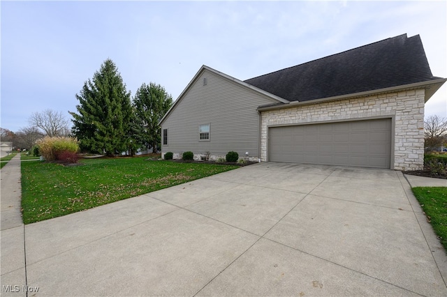 view of side of home featuring a lawn and a garage