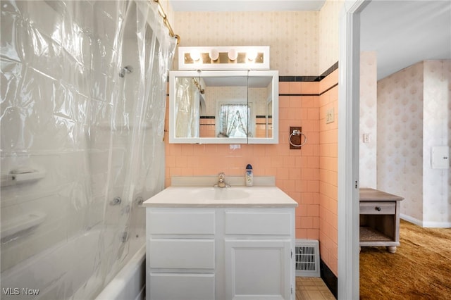 bathroom featuring shower / bath combination with curtain, vanity, and tile walls