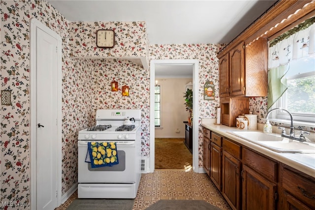 kitchen featuring white gas stove and sink