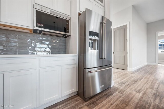 6120 Century Blvd, Canfield, OH 44406 - kitchen with appliances with stainless steel finishes, tasteful backsplash, wood finished floors, and white cabinetry
