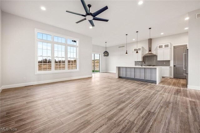 6120 Century Blvd, Canfield, OH 44406 - unfurnished living room featuring light wood-style flooring, recessed lighting, baseboards, a ceiling fan, and a sink