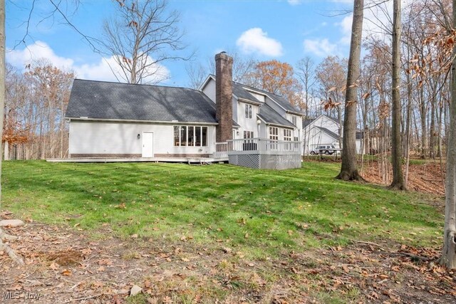 back of property with a lawn and a wooden deck