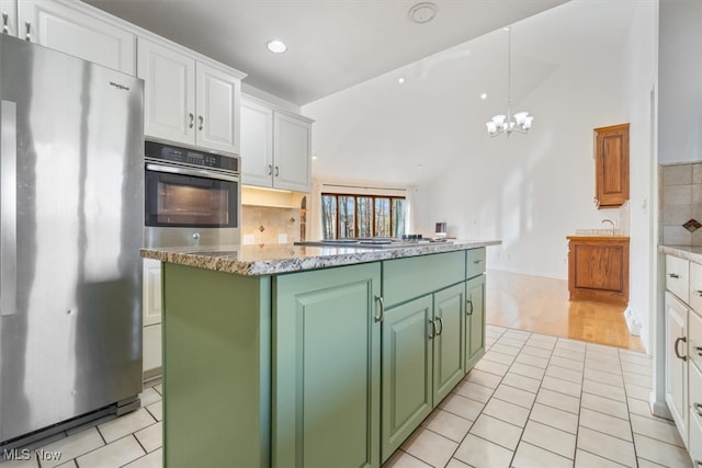 kitchen with white cabinets, a notable chandelier, a center island, and appliances with stainless steel finishes