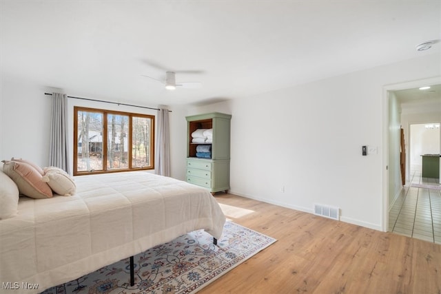 bedroom with ceiling fan and light wood-type flooring