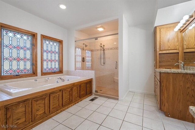 bathroom featuring tile patterned flooring, vanity, and shower with separate bathtub