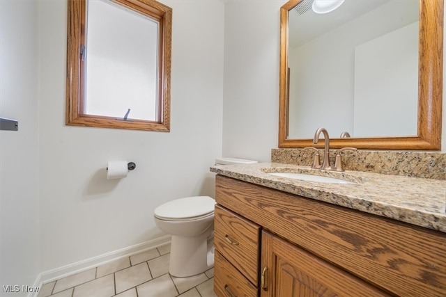 bathroom with tile patterned flooring, vanity, and toilet