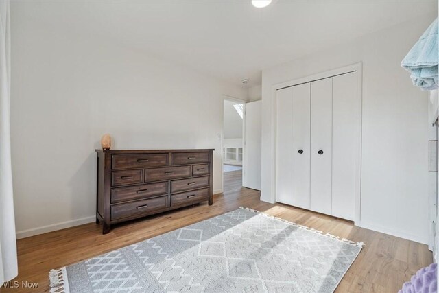 bedroom with light hardwood / wood-style flooring and a closet