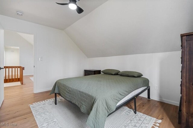 bedroom with hardwood / wood-style flooring, vaulted ceiling, and ceiling fan