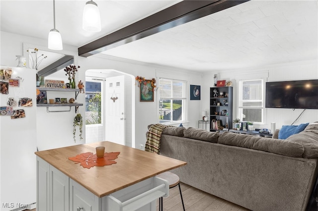 living room with light hardwood / wood-style floors and beam ceiling