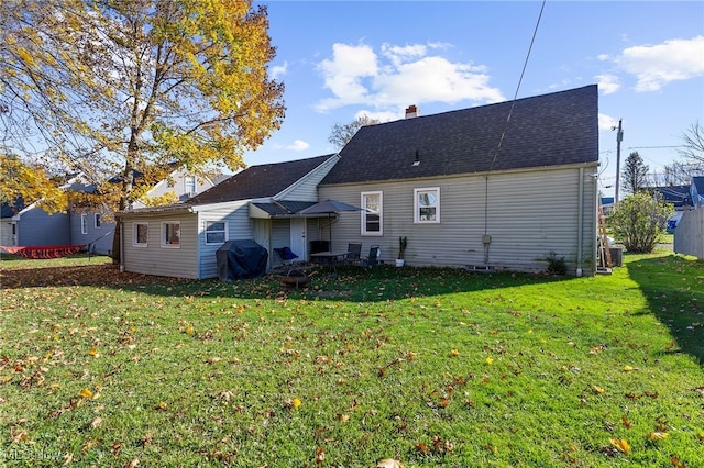 rear view of property featuring a lawn