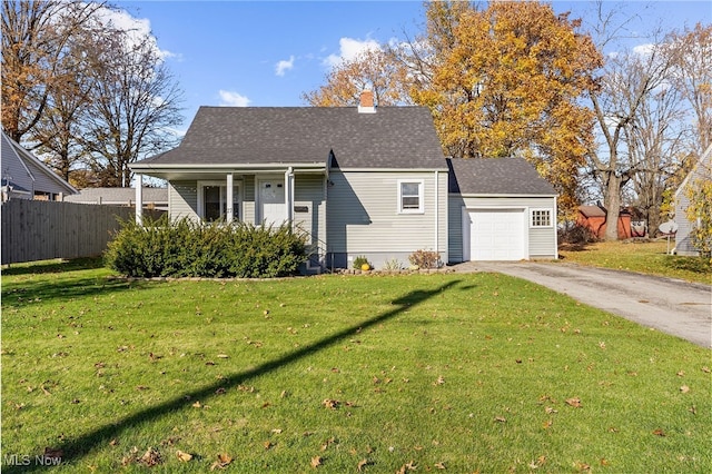 view of front of home featuring covered porch, a garage, and a front lawn