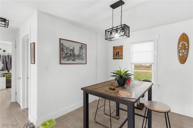 dining room with light hardwood / wood-style flooring and a notable chandelier