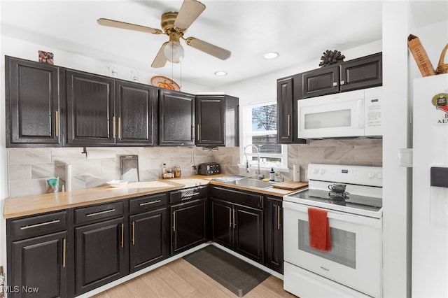 kitchen featuring white appliances, sink, ceiling fan, decorative backsplash, and light hardwood / wood-style floors