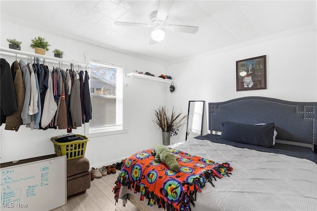 bedroom featuring light hardwood / wood-style flooring, ceiling fan, and crown molding