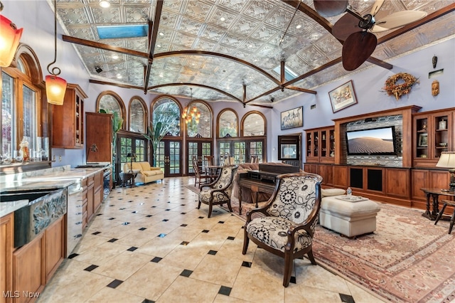 living room featuring ceiling fan with notable chandelier and high vaulted ceiling