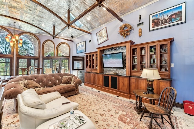 living room with high vaulted ceiling, crown molding, and a notable chandelier