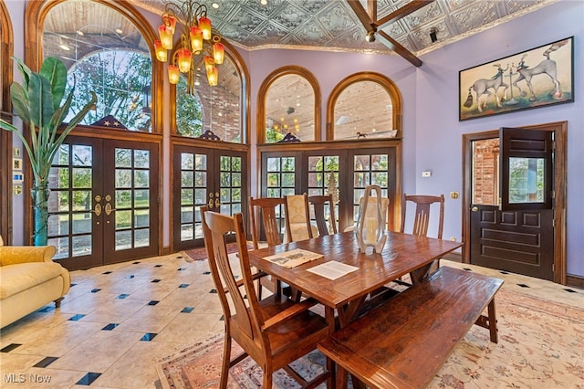 tiled dining area with a high ceiling, a wealth of natural light, and french doors