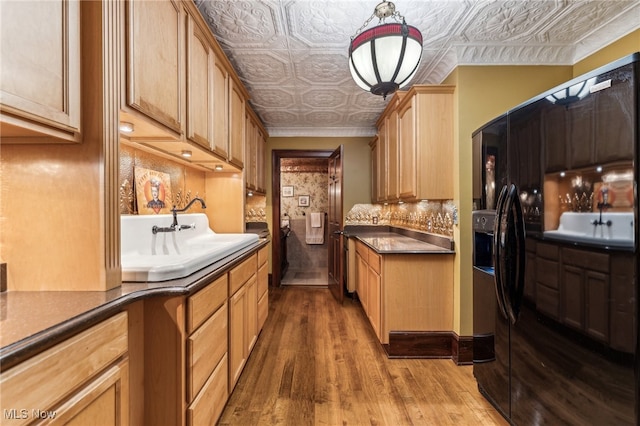 kitchen featuring sink, pendant lighting, light hardwood / wood-style floors, decorative backsplash, and ornamental molding