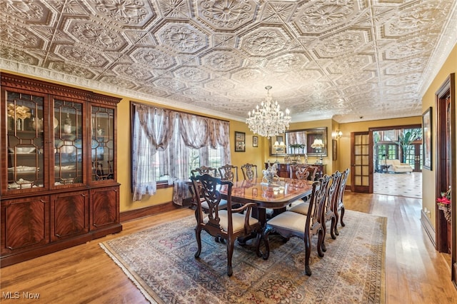 dining room featuring a chandelier, ornamental molding, and hardwood / wood-style flooring