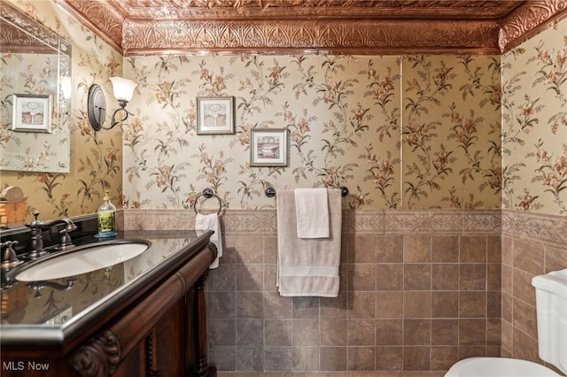 bathroom featuring vanity, tile walls, and toilet