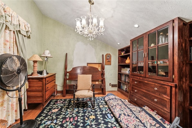 sitting room featuring hardwood / wood-style flooring, a notable chandelier, a textured ceiling, and built in shelves