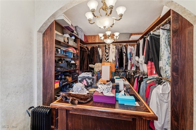 walk in closet with a chandelier