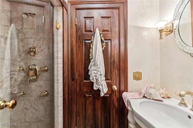 bathroom with a tile shower and sink