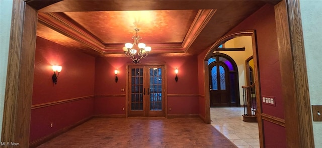 interior space with an inviting chandelier, french doors, crown molding, and a tray ceiling