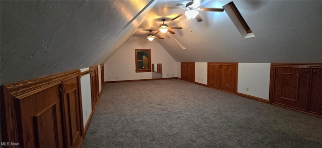 additional living space with carpet, ceiling fan, and vaulted ceiling with skylight