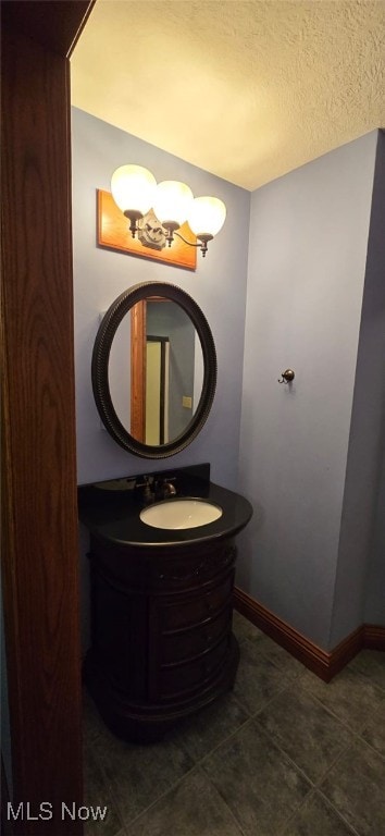 bathroom with a textured ceiling, vanity, and tile patterned floors