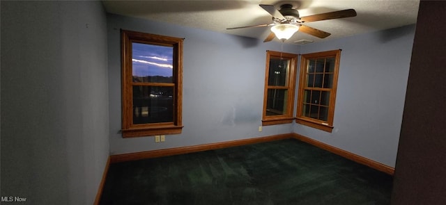 carpeted spare room featuring ceiling fan