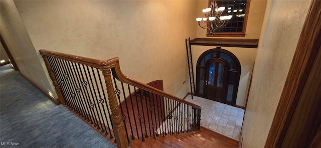 stairs with a chandelier and wood-type flooring