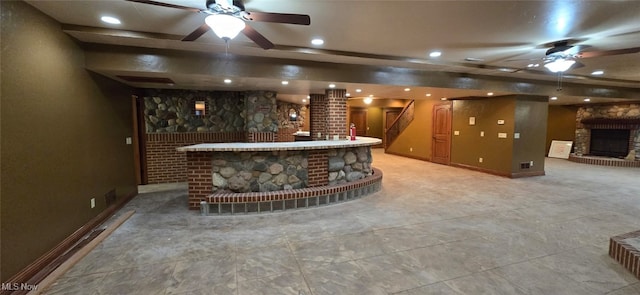 bar with ceiling fan and a fireplace