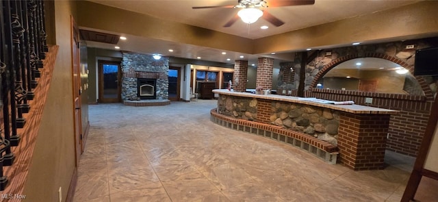 wine area featuring bar, ceiling fan, and a fireplace