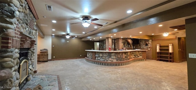 welcome area with a large fireplace and ceiling fan