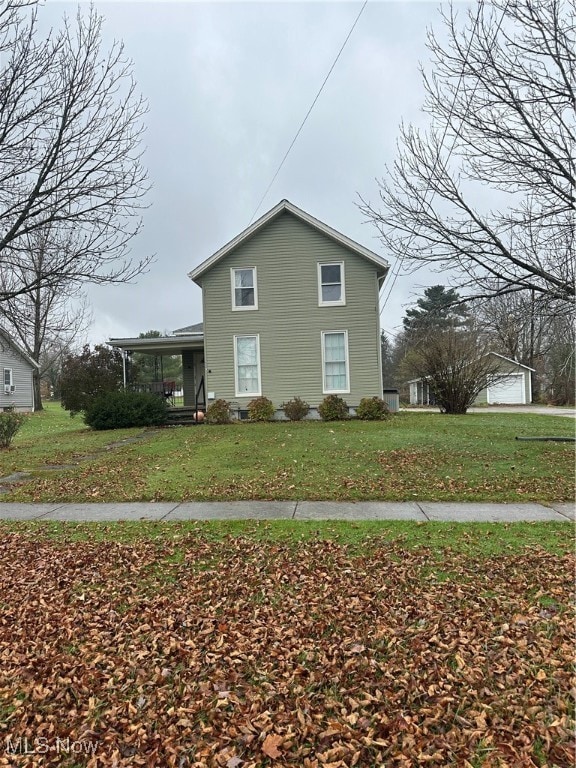 view of side of property featuring an outbuilding, a garage, and a lawn